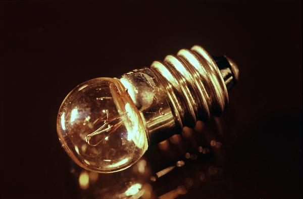 Small light bulb for a torch or flashlight with a screw thread on a dark reflective surface