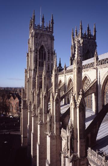 Architectural detail of the structure of a row of flying buttresses, an arched masonry structural support, along the side of a cathedral
