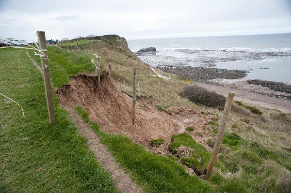 Soil erosion and washaway on a coastal cliff with landslip caused by weathering and water
