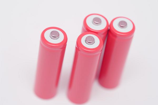 Set of four brandless unlabelled pink batteries viewed high angle with focus to the positive terminals