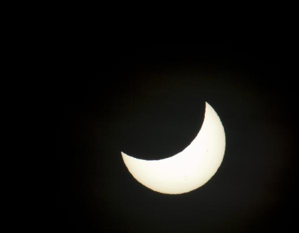 sun in eclipse moon eclipsing the sun with two small sunspots visible
