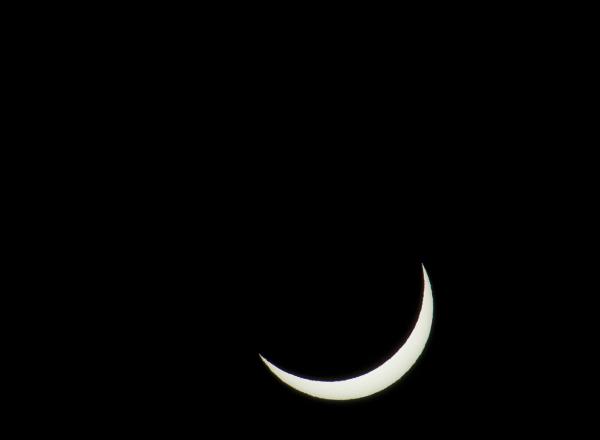 partial solar eclipse crescent penumbra stage of a solar eclipse, with the moon almost covering the sun leavng only a narrow crescent