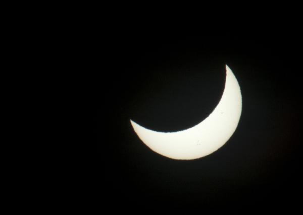 partial solar crescent The sun as pictured through a dark filter during a solar eclipse, partially blocked by the moon