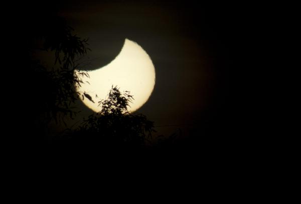 partial solar eclipse The moon starting to block out the sun during a total solar eclipse, the transit into darkness takes approximately 1 hour
