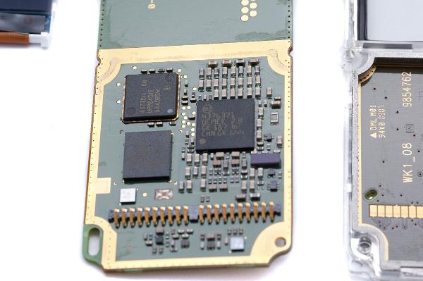 microelectronics electronic circuitboard from a mobile phone, contains tiny components laid out in a grid formation, the black resin encapsulated larger components are integrated circuits containing many thousands of individual components laid out on a silicon die