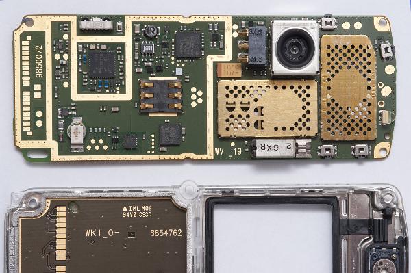 Disassembled Mobile Phone Parts Disassembled Mobile Phone Parts on white background. the gold coloured metal structed on the right are RF screening cans which protect the radio circuits within the phone from interference