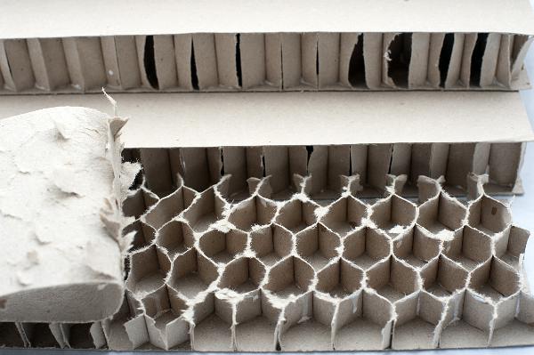 cardboard honeycomb a cardboard lattice, think sheets of card formed into hexagonable shapes and glued between further layers of card produce a strong boardlike material