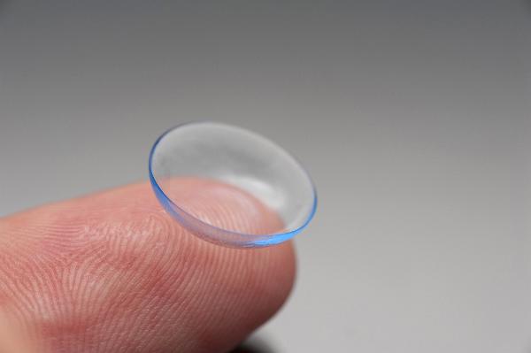 Contact lens on a finger Blue tinted disposable plastic contact lens on a finger for corrective vision