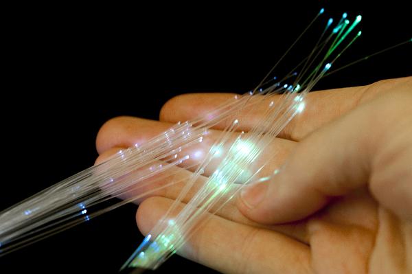 Hand holding optical fibers Hand holding optical fibers close up on black background