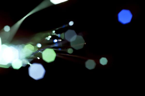 abstract fiber optics blue and green light being emitted from fibre optic cables,